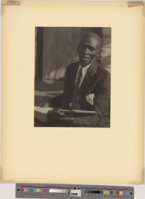 African-American man in suit, with book (recto)