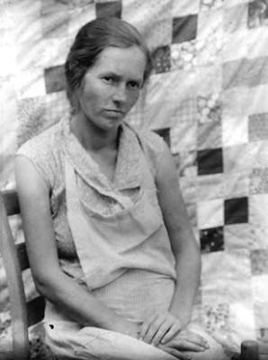Woman in front of block quilt