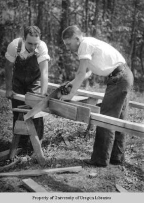 Students building a house, Berea College: two men cutting wood for framing