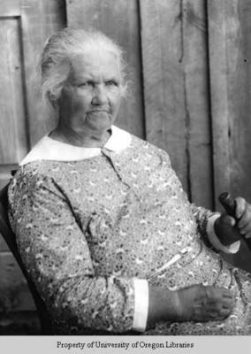 Elderly woman by cabin