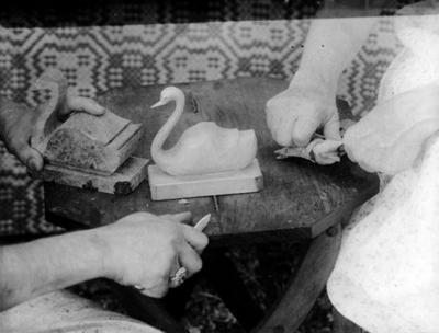 Hands of John Jacob Niles and Aline Dane Campbell, carving wooden swans