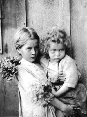 Girl holding little girl with flowers