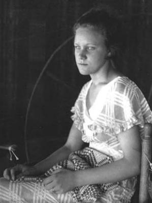 Daughter of Delia Justice: young woman by spinning wheel