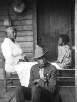 African-American woman, man and child, on a porch